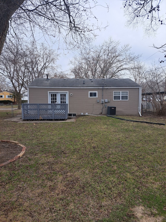 rear view of house featuring central AC unit, a lawn, fence, and a wooden deck
