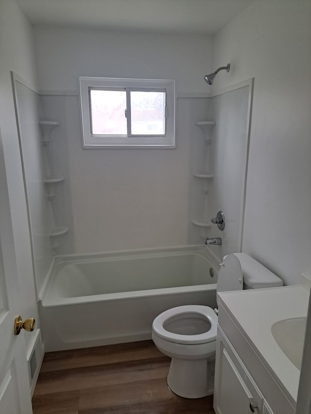 bathroom with visible vents, toilet, vanity, wood finished floors, and washtub / shower combination