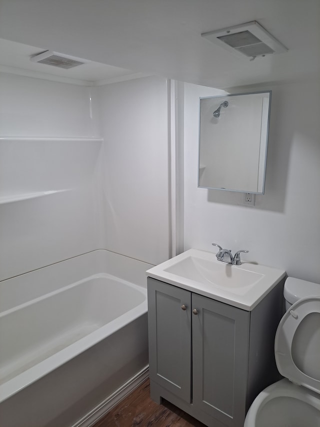 bathroom featuring vanity, toilet, wood finished floors, and visible vents