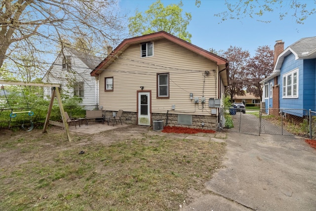 rear view of house with fence, a gate, and a patio area
