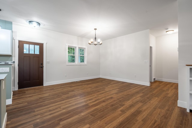 foyer entrance featuring baseboards, a chandelier, and dark wood finished floors