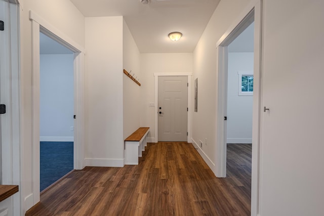 hall with baseboards and dark wood-style flooring