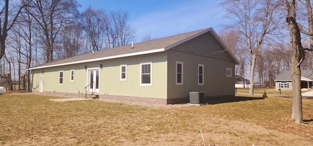 view of side of property featuring central air condition unit, a lawn, and entry steps