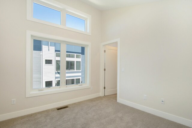 631 Fairview Ave NE Unit 3, Grand Rapids, MI 49503 - empty room with visible vents, baseboards, a high ceiling, and carpet