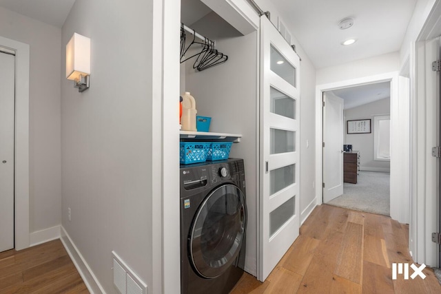 631 Fairview Ave NE Unit 3, Grand Rapids, MI 49503 - washroom with visible vents, baseboards, laundry area, light wood-style flooring, and washer / clothes dryer