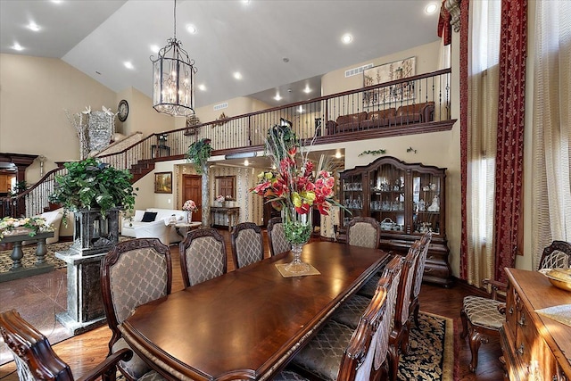 1270 John R Rd, Rochester Hills, MI 48307 - dining space with visible vents, stairs, wood finished floors, a notable chandelier, and high vaulted ceiling