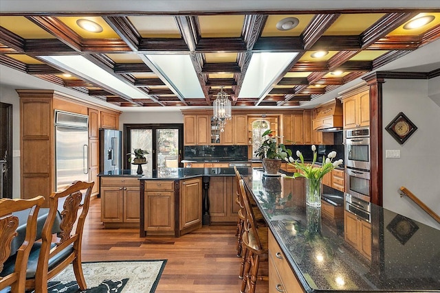 1270 John R Rd, Rochester Hills, MI 48307 - kitchen featuring brown cabinetry, coffered ceiling, stainless steel appliances, a large island, and dark wood-type flooring