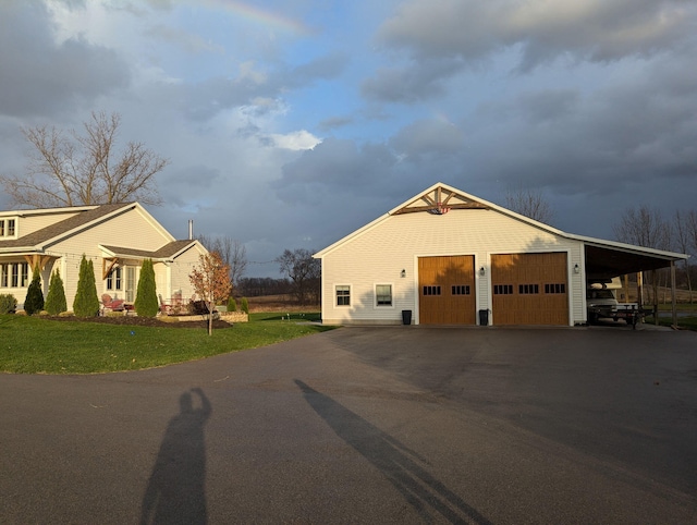 view of property exterior with driveway, a detached garage, and a lawn