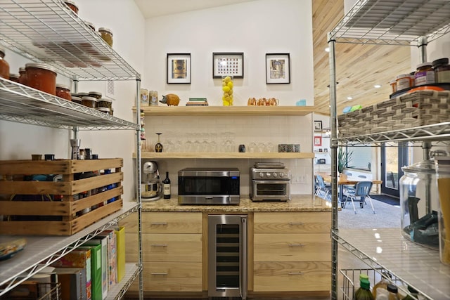 5595 Riverview Dr, Bridgeport, MI 48722 - bar featuring beverage cooler, stainless steel microwave, and carpet