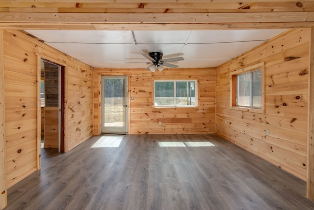 2340 Ryno Rd, Luzerne, MI 48636 - empty room featuring wood walls, dark wood-type flooring, and ceiling fan