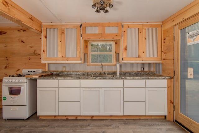 2340 Ryno Rd, Luzerne, MI 48636 - kitchen featuring white range with gas cooktop, white cabinetry, wooden walls, and wood finished floors