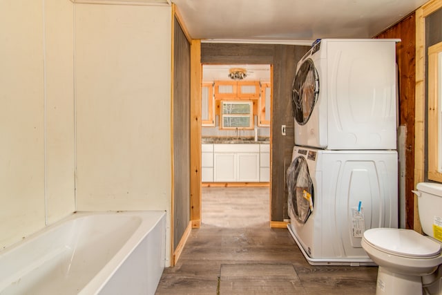 2340 Ryno Rd, Luzerne, MI 48636 - full bathroom with a washtub, toilet, wood finished floors, vanity, and stacked washer / drying machine