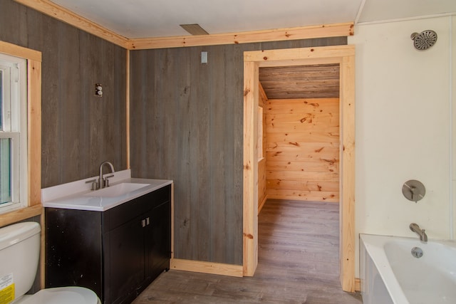 2340 Ryno Rd, Luzerne, MI 48636 - bathroom featuring wooden walls, toilet, a bathing tub, and wood finished floors