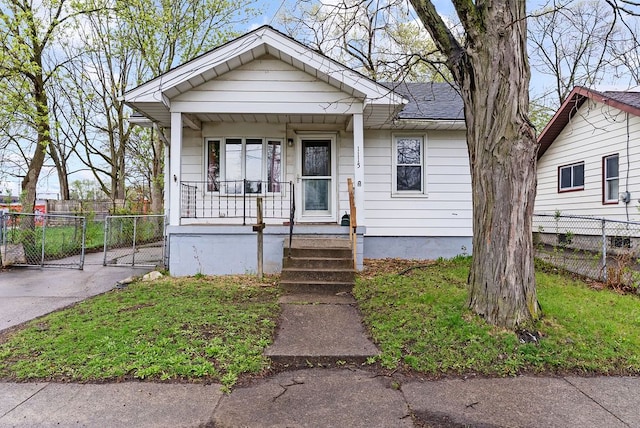 view of front of home with a porch, a gate, and fence
