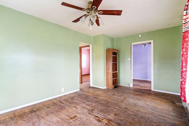 spare room with baseboards, ceiling fan, and wood finished floors