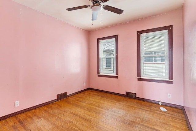 spare room with visible vents, light wood-style flooring, ceiling fan, and baseboards