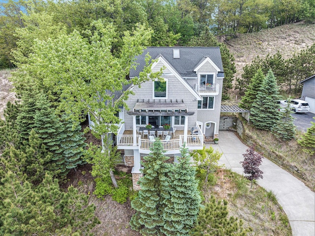 19148 Maiden Ln, Spring Lake, MI 49456 - view of front of house with a balcony, a shingled roof, concrete driveway, view of scattered trees, and a pergola