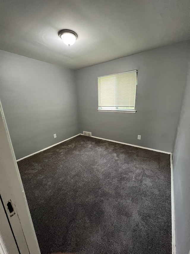 13900 Sussex St, Detroit, MI 48227 - empty room featuring visible vents, dark carpet, and baseboards