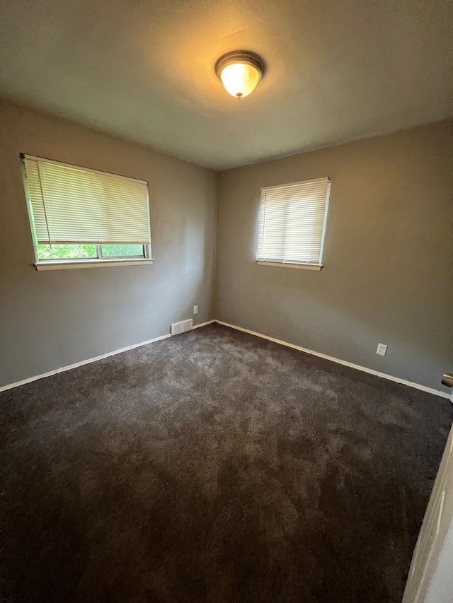 13900 Sussex St, Detroit, MI 48227 - unfurnished room featuring visible vents, dark carpet, and baseboards