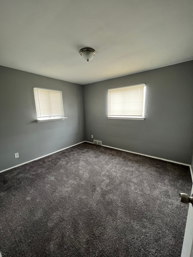 13900 Sussex St, Detroit, MI 48227 - unfurnished room featuring visible vents, dark carpet, and baseboards