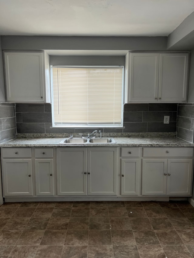 13900 Sussex St, Detroit, MI 48227 - kitchen featuring a sink, backsplash, and white cabinets