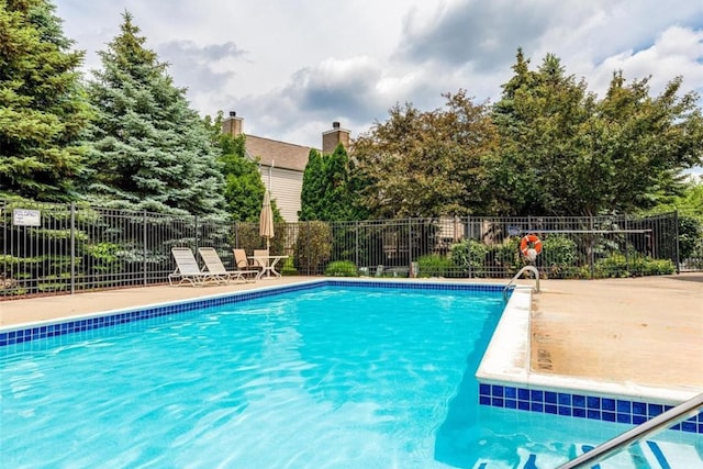 community pool featuring a patio and fence