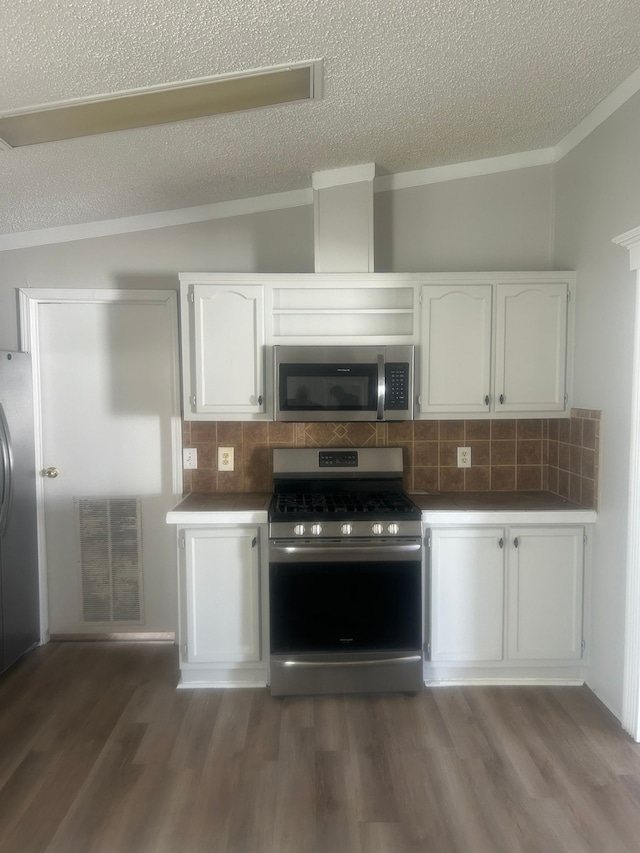 kitchen with white cabinets, dark wood-style flooring, appliances with stainless steel finishes, and visible vents