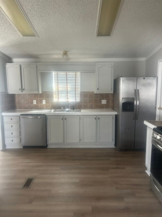 kitchen featuring light countertops, visible vents, stainless steel appliances, a sink, and light wood-style floors