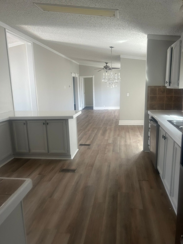 kitchen with light countertops, crown molding, a textured ceiling, and wood finished floors