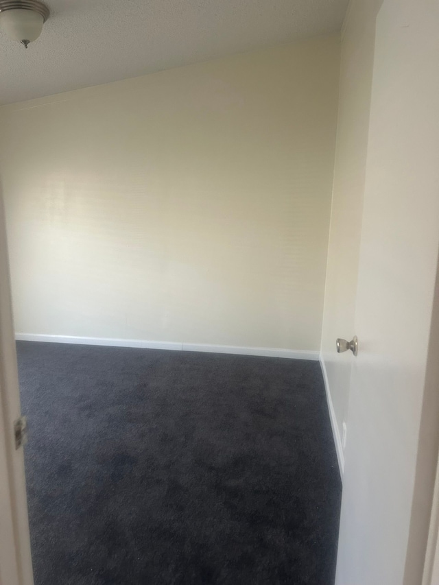 carpeted spare room featuring baseboards