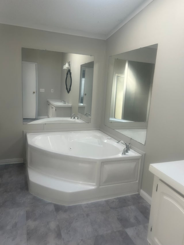 full bathroom featuring baseboards, a garden tub, and vanity
