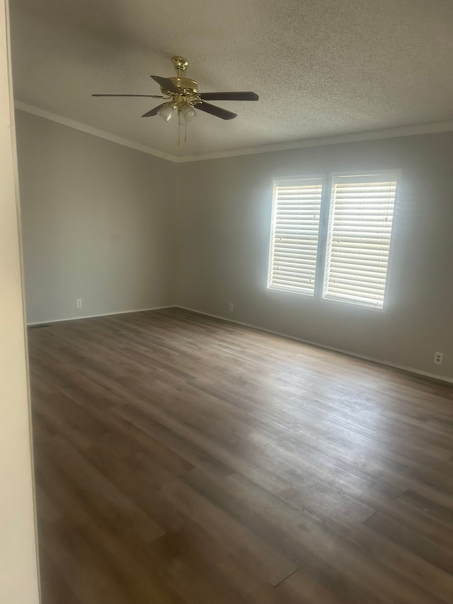empty room featuring dark wood finished floors, a textured ceiling, ornamental molding, and a ceiling fan