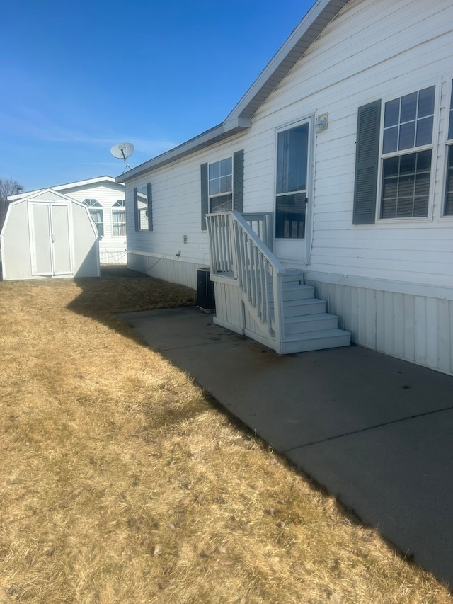 view of home's exterior featuring a storage unit, a lawn, and an outbuilding