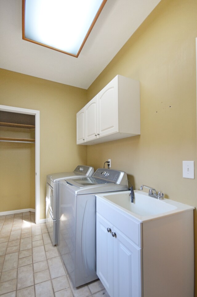 clothes washing area featuring washing machine and clothes dryer, cabinet space, baseboards, and light tile patterned flooring