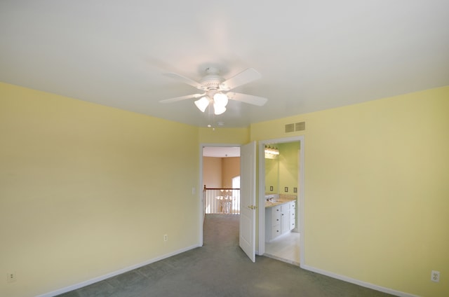 spare room featuring baseboards, visible vents, ceiling fan, and carpet