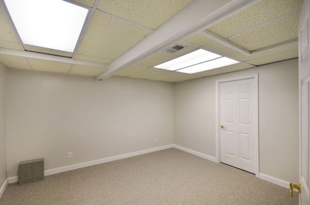 unfurnished room featuring a drop ceiling, carpet, and baseboards
