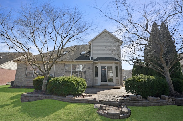 back of house with a patio, brick siding, and a lawn