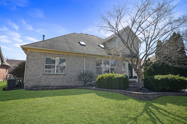 exterior space featuring brick siding, a shingled roof, cooling unit, and a front yard