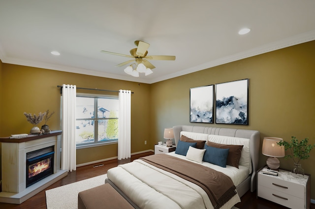 bedroom featuring crown molding, recessed lighting, baseboards, a glass covered fireplace, and wood finished floors