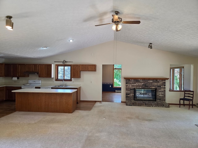 3380 Watersedge Dr, Brighton, MI 48114 - kitchen featuring electric range oven, a sink, light carpet, lofted ceiling, and plenty of natural light