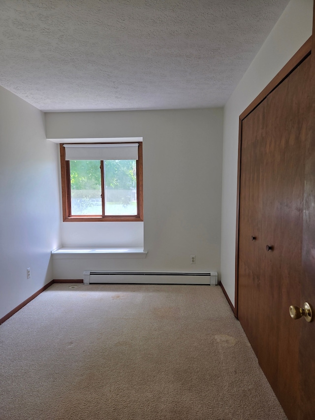 3380 Watersedge Dr, Brighton, MI 48114 - unfurnished bedroom featuring carpet floors, a closet, a baseboard heating unit, a textured ceiling, and baseboards