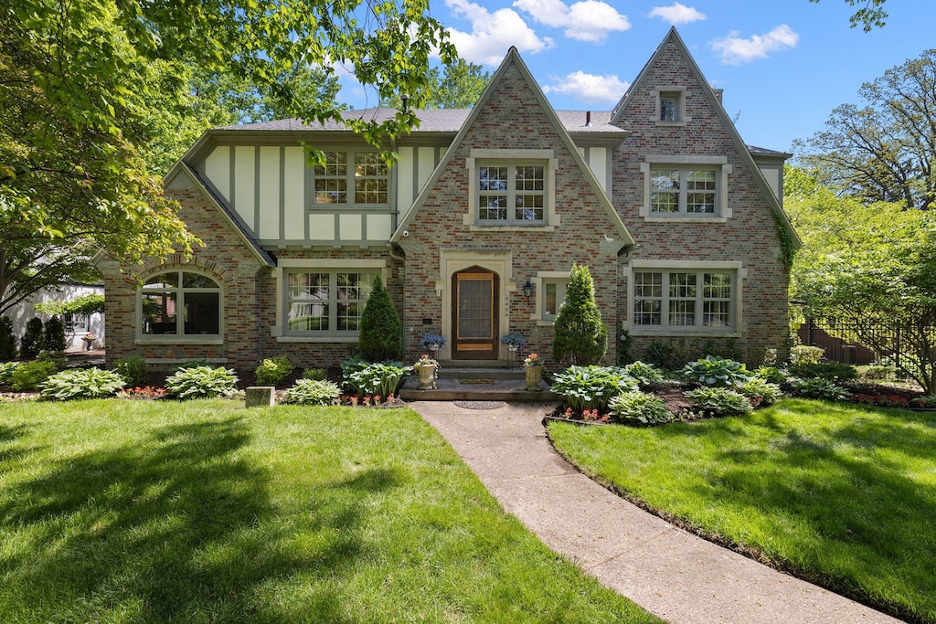 19494 Suffolk Dr, Detroit, MI 48203 - tudor house featuring brick siding, board and batten siding, and a front yard