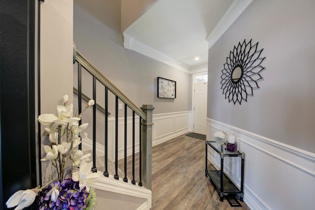 foyer entrance with recessed lighting, wood finished floors, wainscoting, ornamental molding, and stairway