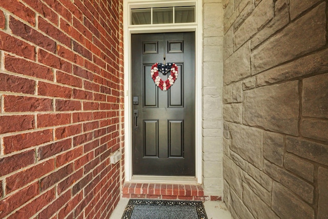view of exterior entry featuring brick siding