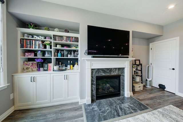 living room featuring wood finished floors, recessed lighting, a high end fireplace, and baseboards