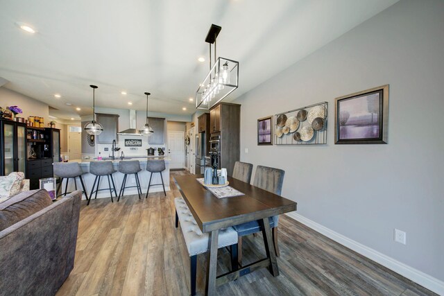 dining space featuring wood finished floors, recessed lighting, and baseboards