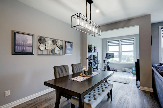 dining area with an inviting chandelier, baseboards, and dark wood finished floors