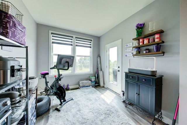 workout area with baseboards and light wood-style floors