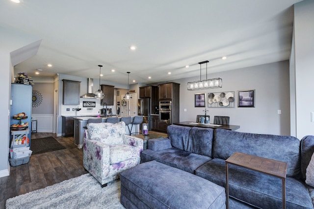 living area with dark wood-type flooring, recessed lighting, and wainscoting