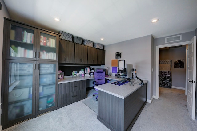 office space with recessed lighting, light colored carpet, built in desk, baseboards, and visible vents